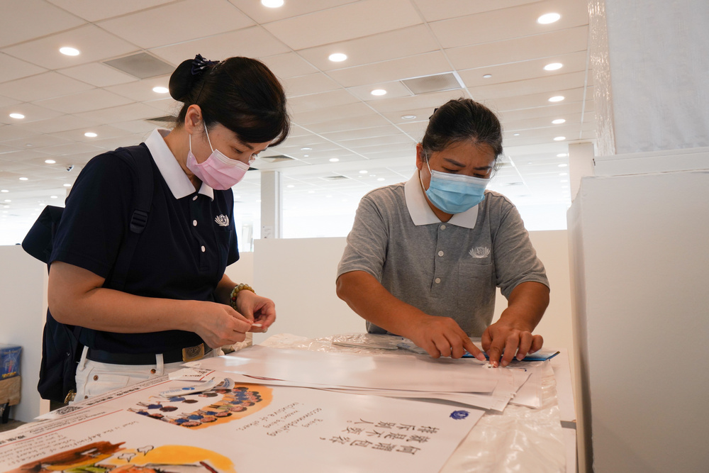 Tzu Chi volunteer Ms Choy Sio Hoon (right) in the midst of preparing the posters to be pasted up. (Photo by Chan May Ching)