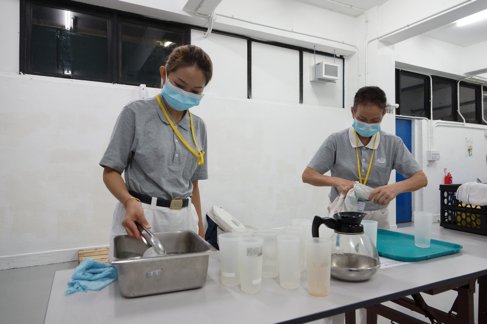 Volunteers in the midst of washing the cups thoroughly before tea is added. (Photo by Chan May Ching)