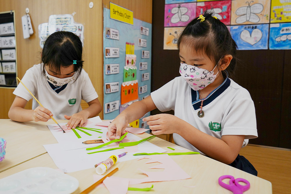 Children make a greeting card by themselves by drawing and pasting coloured paper to prepare a surprise for their parents. (Photo by Chan May Ching)
